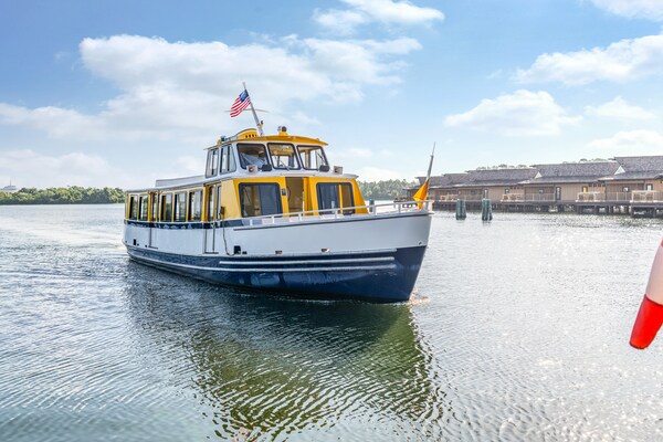 A water taxi approaching a dock at Disney’s Polynesian Village Resort