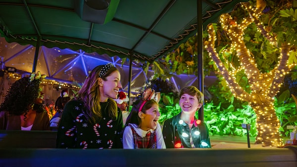 A mother and her 2 children delight in the festive lights at Epcot 