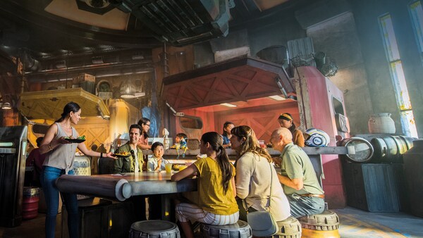 Los visitantes de Black Spire Outpost examinan platos de comida de toda la galaxia en Docking Bay 7 Food and Cargo