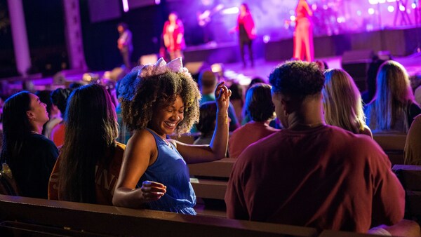 Guests smiling and dancing in their seats as they watch a band perform on a stage