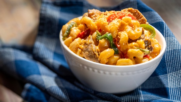 A bowl of Cheesesteak Macaroni and Cheese mixed with shaved beef, peppers, onions and herbed panko