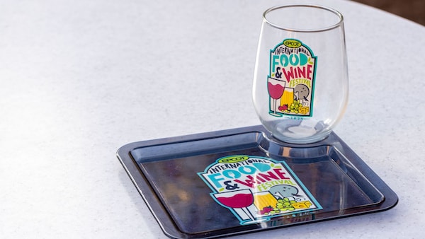 A glass and a small food tray that say, 'Epcot International Food & Wine Festival 2024'