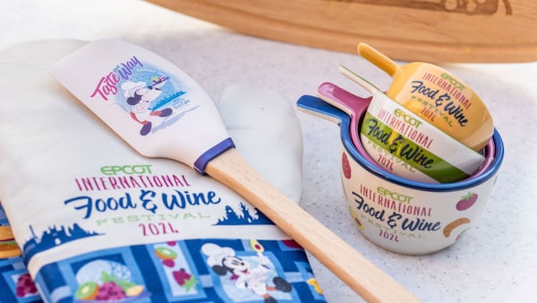 An oven mitt, spatula and measuring cups that say, 'Epcot International Food & Wine Festival 2024'