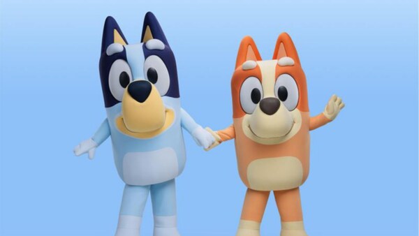 Bluey y Bingo, de la serie animada Bluey, tomados de la mano y sonriendo 