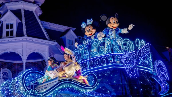 Mickey Mouse, Minnie Mouse, Jasmine and Aladdin on an illuminated parade float at night