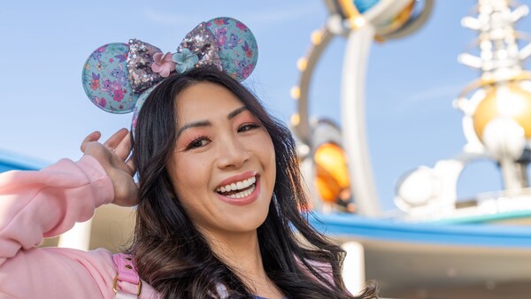 A woman wearing a Stitch themed Minnie Mouse ear headband at Tomorrowland