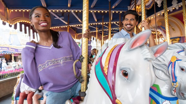 Two Guests smiling as they ride Prince Charming Regal Carrousel