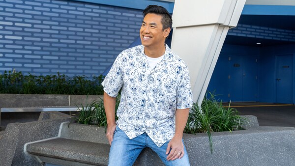 A Guest wearing a button down shirt featuring Stitch