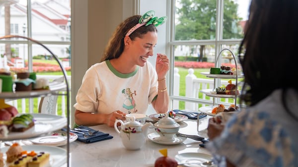A Guest enjoying afternoon tea with tiered trays of pastries at The Garden View Lounge Tea Experience