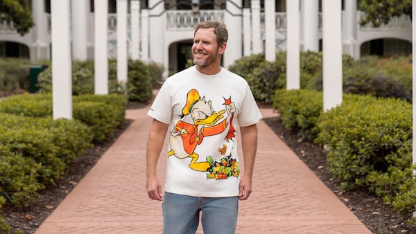 A Guest wears a Donald Duck Halloween themed T shirt while walking along a landscaped pathway