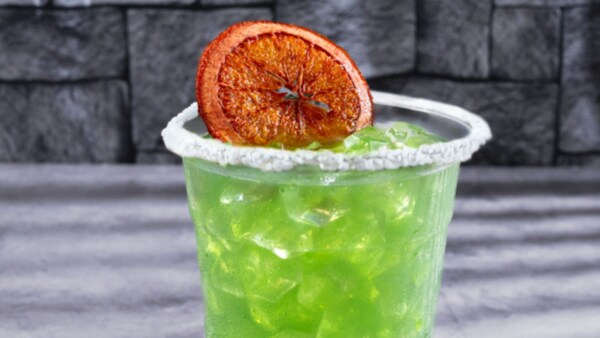 A Halloween cocktail with a salted rim and dried orange slice garnish from Dockside Margaritas