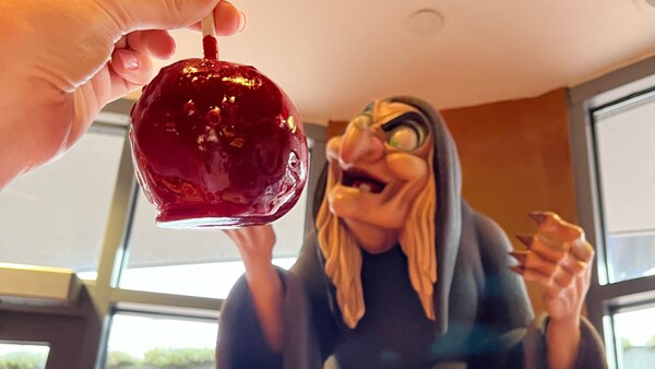 A caramel apple near the witch from Snow White and the Seven Dwarfs at Disney's Candy Cauldron