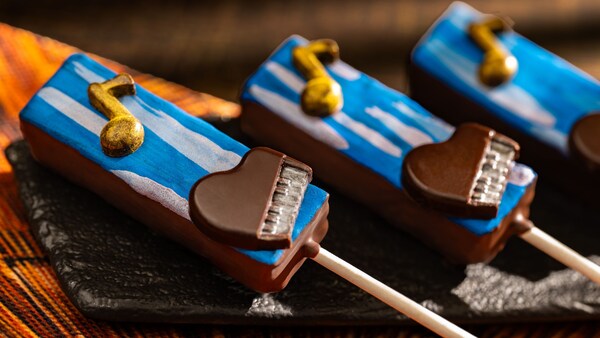 A trio of cake pops with a music note and piano design styled after the movie Soul