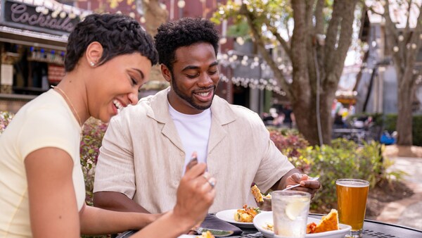 A man and a woman enjoying a meal at an outdoor table at House of Blues