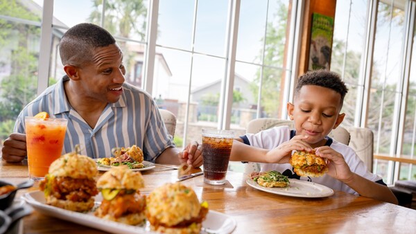 A father and his son enjoying sandwiches from Chef Art Smith's Homecomin' at Disney Springs