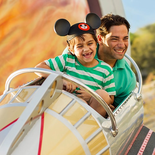 A father and son riding Astro Orbiter
