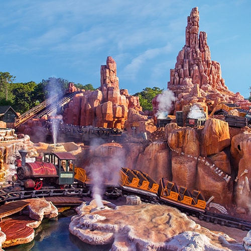 Trains coasting along the tracks as geysers erupt at Big Thunder Mountain Railroad