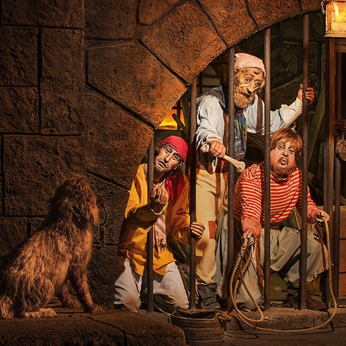 A scene from the Pirates of the Caribbean attraction featuring the prison dog guarding Fort Charles prison in Port Royal
