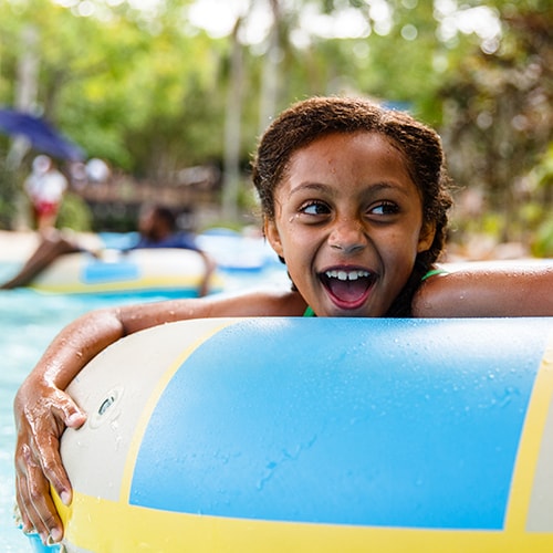 A girl holding onto an inner tube while floating down Castaway Creek