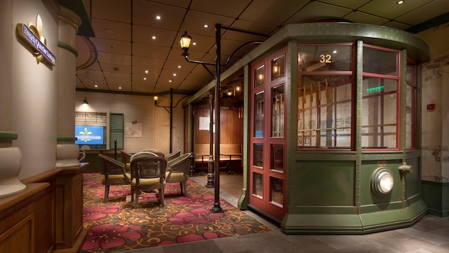 Una sección del salón French Quarter Lounge con una mesa con sillas y un área para sentarse dentro de una réplica de tranvía Una sección del salón French Quarter Lounge con una mesa con sillas y un área para sentarse dentro de una réplica de tranvía