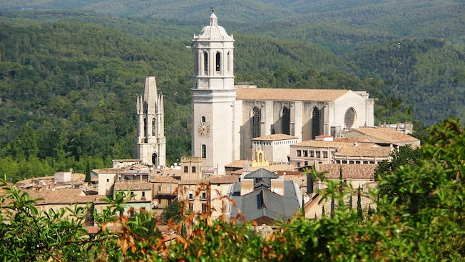 Verdant mountains surround a medieval town with a cathedral Verdant mountains surround a medieval town with a cathedral