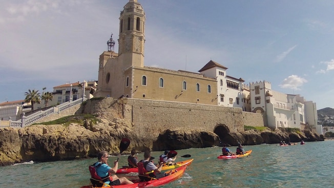Kayakers paddling in the waters fronting a cathedral Kayakers paddling in the waters fronting a cathedral