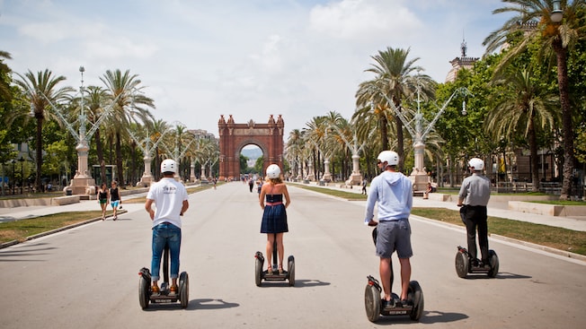 Quatro hóspedes fazendo um passeio de Segway, descendo por um caminho cercado de palmeiras Quatro hóspedes fazendo um passeio de Segway, descendo por um caminho cercado de palmeiras