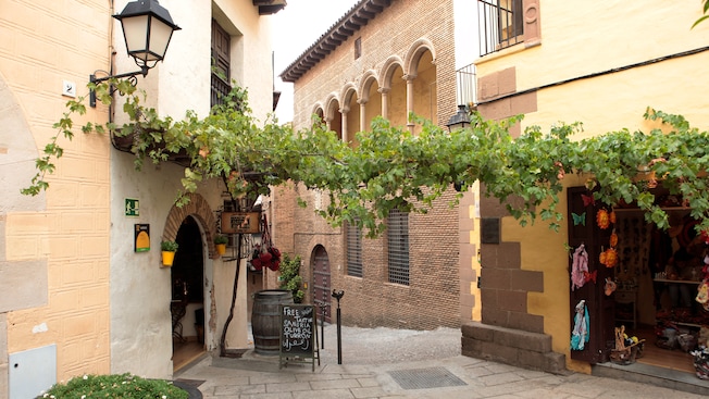 Um galho de hera adornando um beco estreito, repleto de réplicas da arquitetura tradicional espanhola Um galho de hera adornando um beco estreito, repleto de réplicas da arquitetura tradicional espanhola