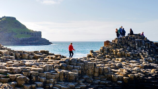 Visitantes caminando por las piedras de Giant's Causeway