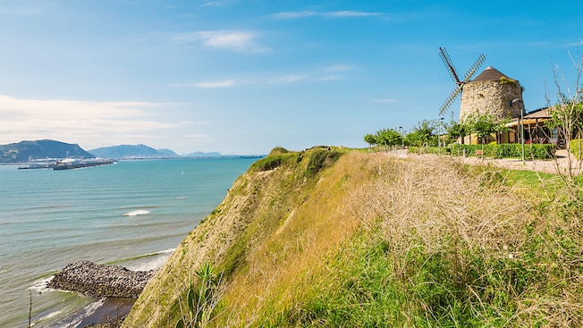 A rustic windmill on a coastal hill
