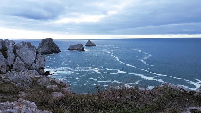 A series of low sea stacks off a rocky coast A series of low sea stacks off a rocky coast