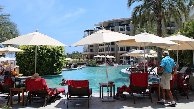 Hóspedes relaxam e nadam em uma piscina livre em um resort Hóspedes relaxam e nadam em uma piscina livre em um resort
