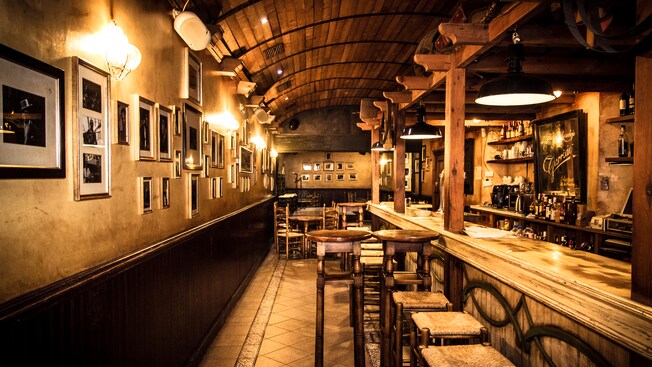 Uma taberna tradicional com piso de azulejo e bar de madeira