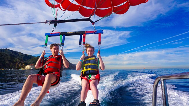 A young man and woman parasailing near Catalina island