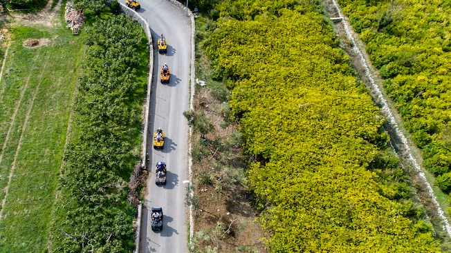 A caravan of ATVs traveling on a curvy country road A caravan of ATVs traveling on a curvy country road