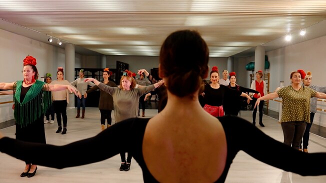 An instructor in a dance studio facing her students