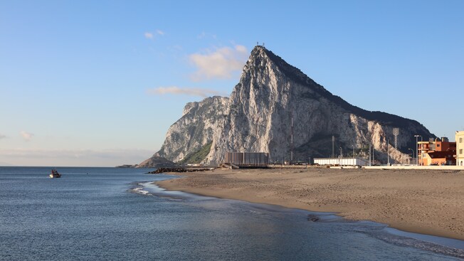 A sandy seashore next to the Rock of Gibraltar