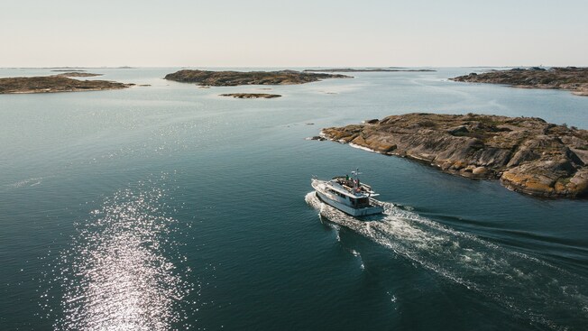 A 2 level boat sailing through waters dotted with islets and islands