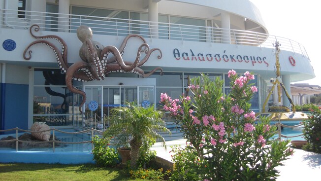 Exterior of the Thalassocosmos Aquarium featuring a larger than life octopus adornment above the entrance