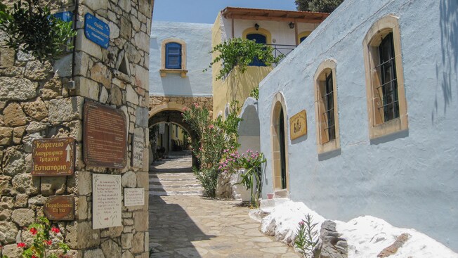 A Greek neighborhood featuring arches, rustic architecture and a stone walkway with steps