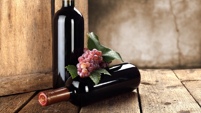 2 garrafas de vinho com uvas