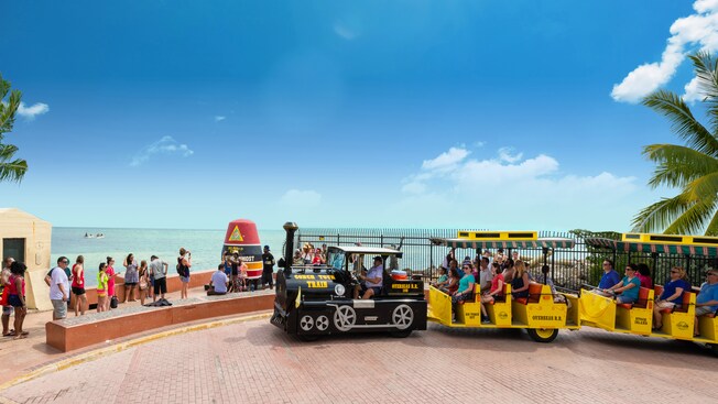 Guests in a open air vehicle traveling by signage for the southernmost point of the continental United States
