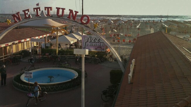 Un letrero arqueado que dice Nettuno en la entrada del paseo marítimo