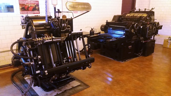 An exhibit showcasing an antique printing press An exhibit showcasing an antique printing press