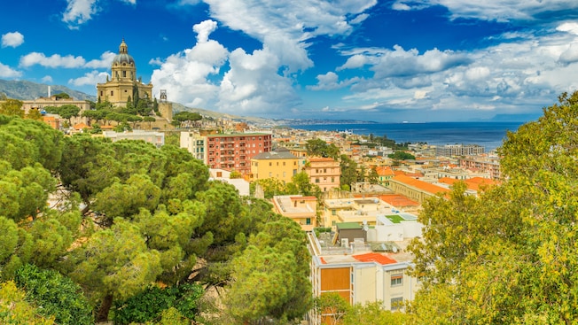 A domed church on a hill overlooking a coastal European village