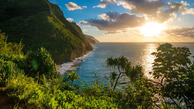 The sun on the horizon of a coastal mountain range