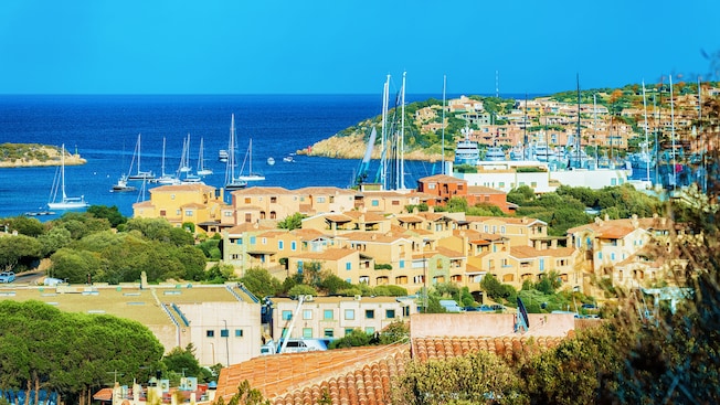 A coastal village with boats moored in the water and multistory Mediterranean architecture A coastal village with boats moored in the water and multistory Mediterranean architecture