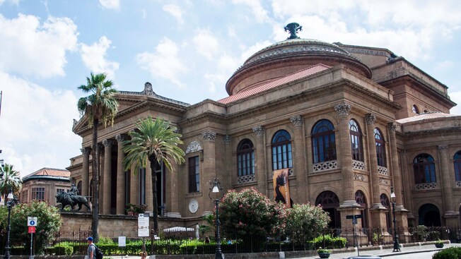 A multi-story building with a dome and multiple columns spans nearly a block