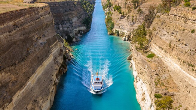 A boat sailing through a narrow canal A boat sailing through a narrow canal