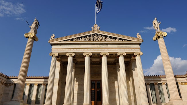 A Greek flag flying over a monumental structure built in the neoclassical style A Greek flag flying over a monumental structure built in the neoclassical style